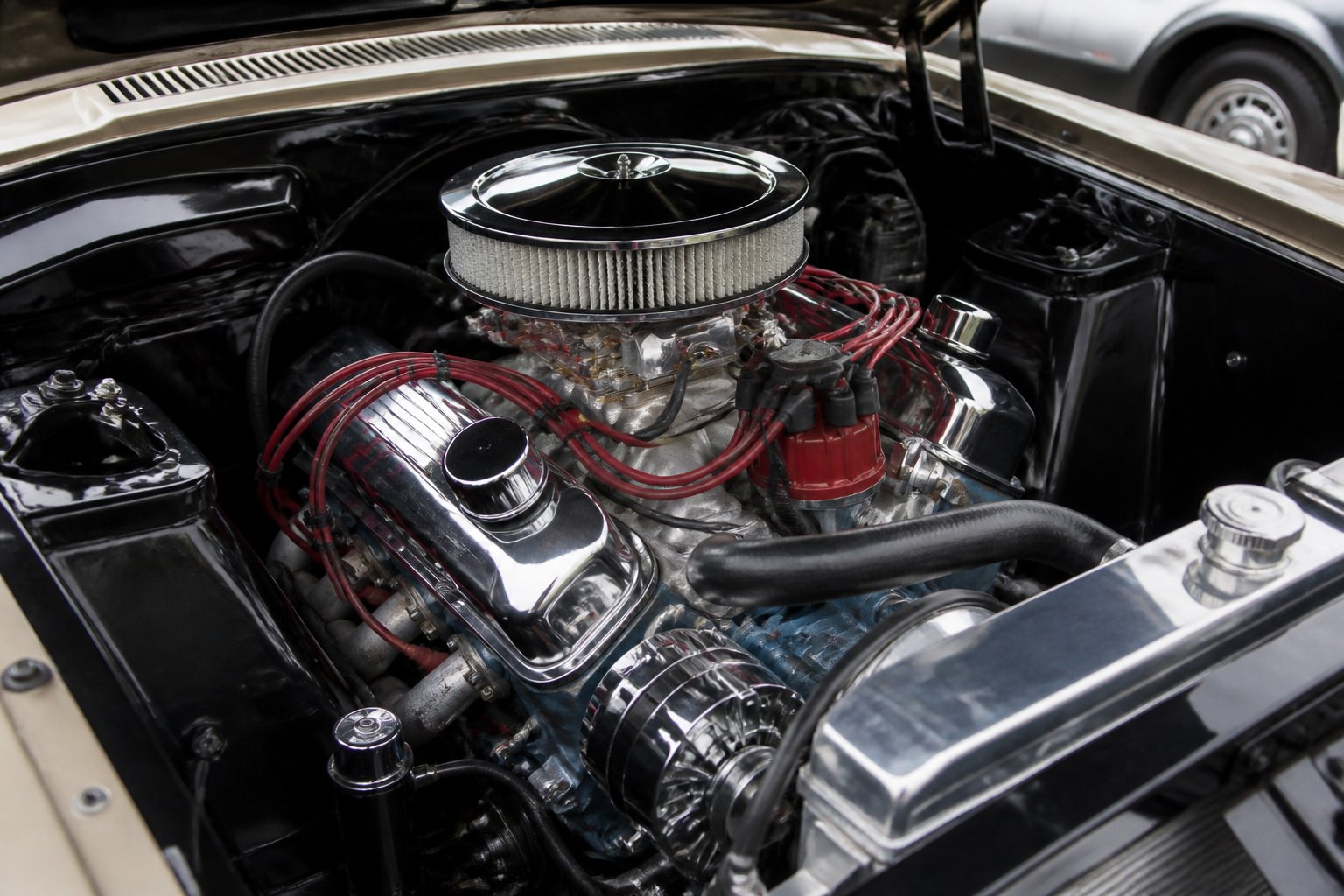 Close-up of a classic 1960s muscle car engine with a polished small-block V8 and shiny chrome parts.