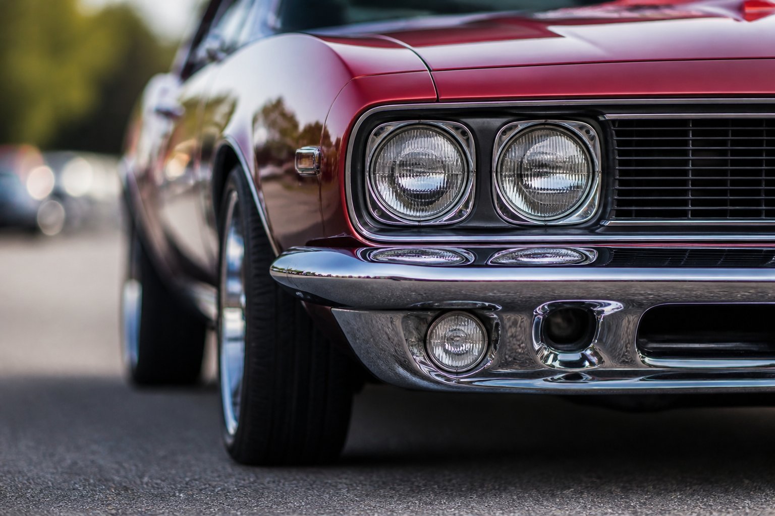 Close-up of the front chrome bumper and shiny metal detailing on a classic 1960s muscle car.