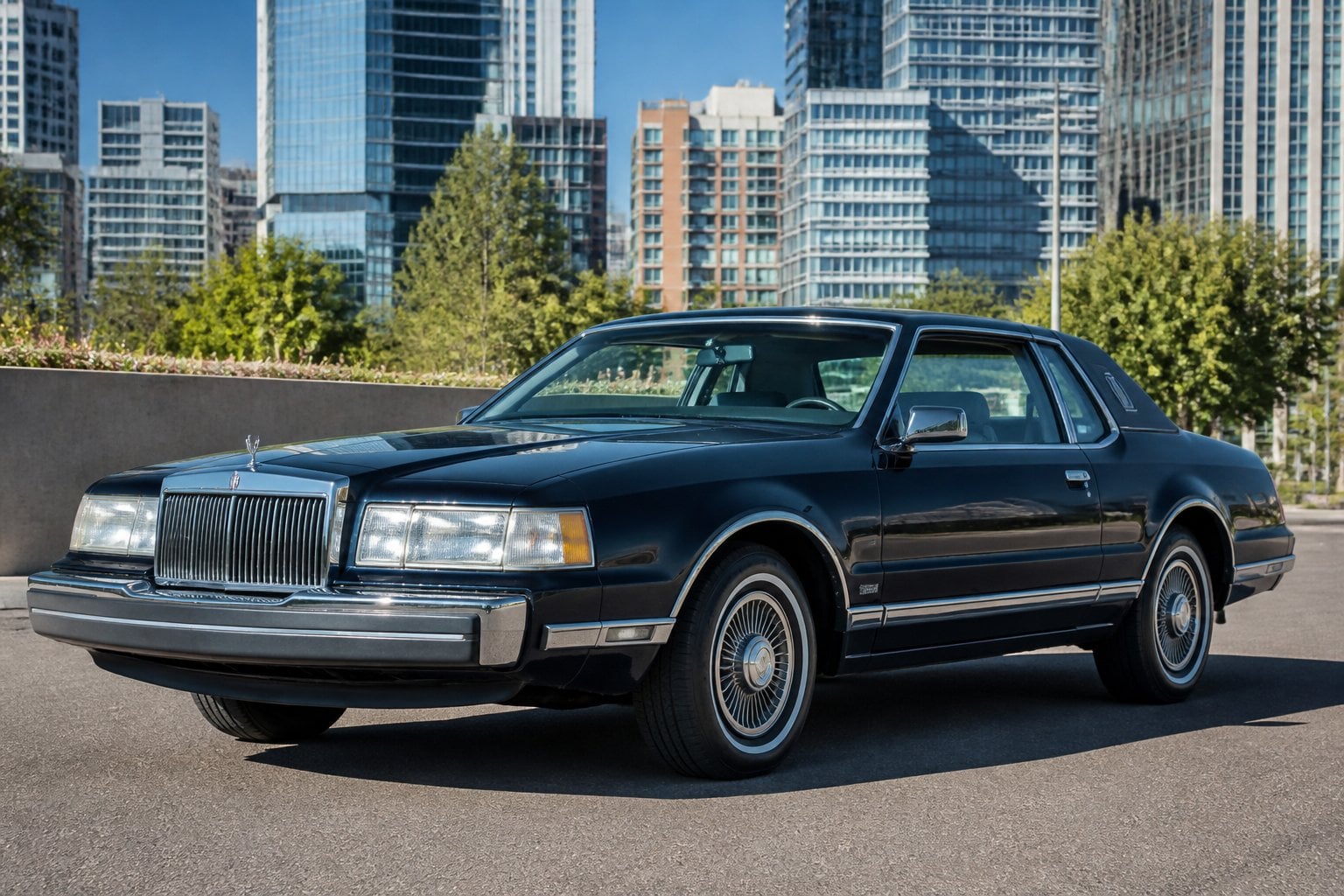A dark blue 1980s Lincoln Continental Mark VII parked on a city street with buildings and trees in the background.