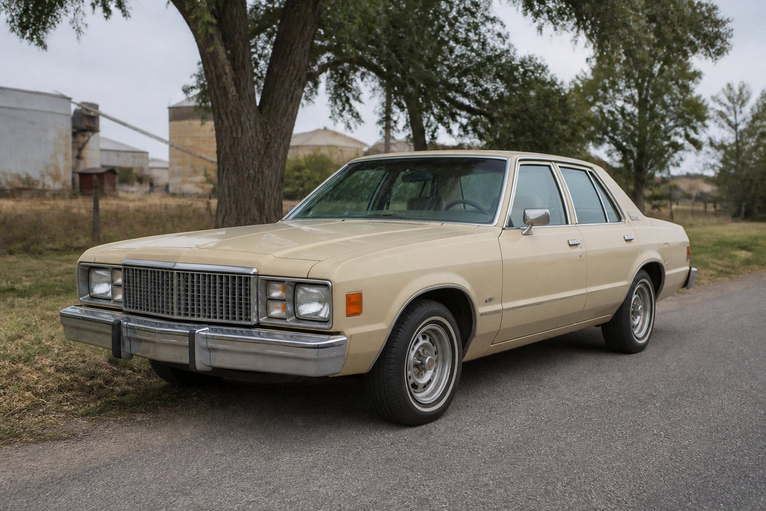 A weathered late-1970s Dodge Aspen sedan parked beside a quiet roadside.