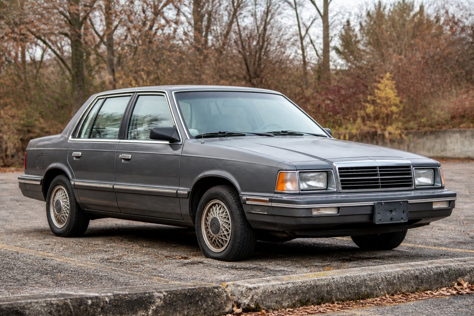 An older boxy Dodge Dynasty sedan parked in a suburban lot.