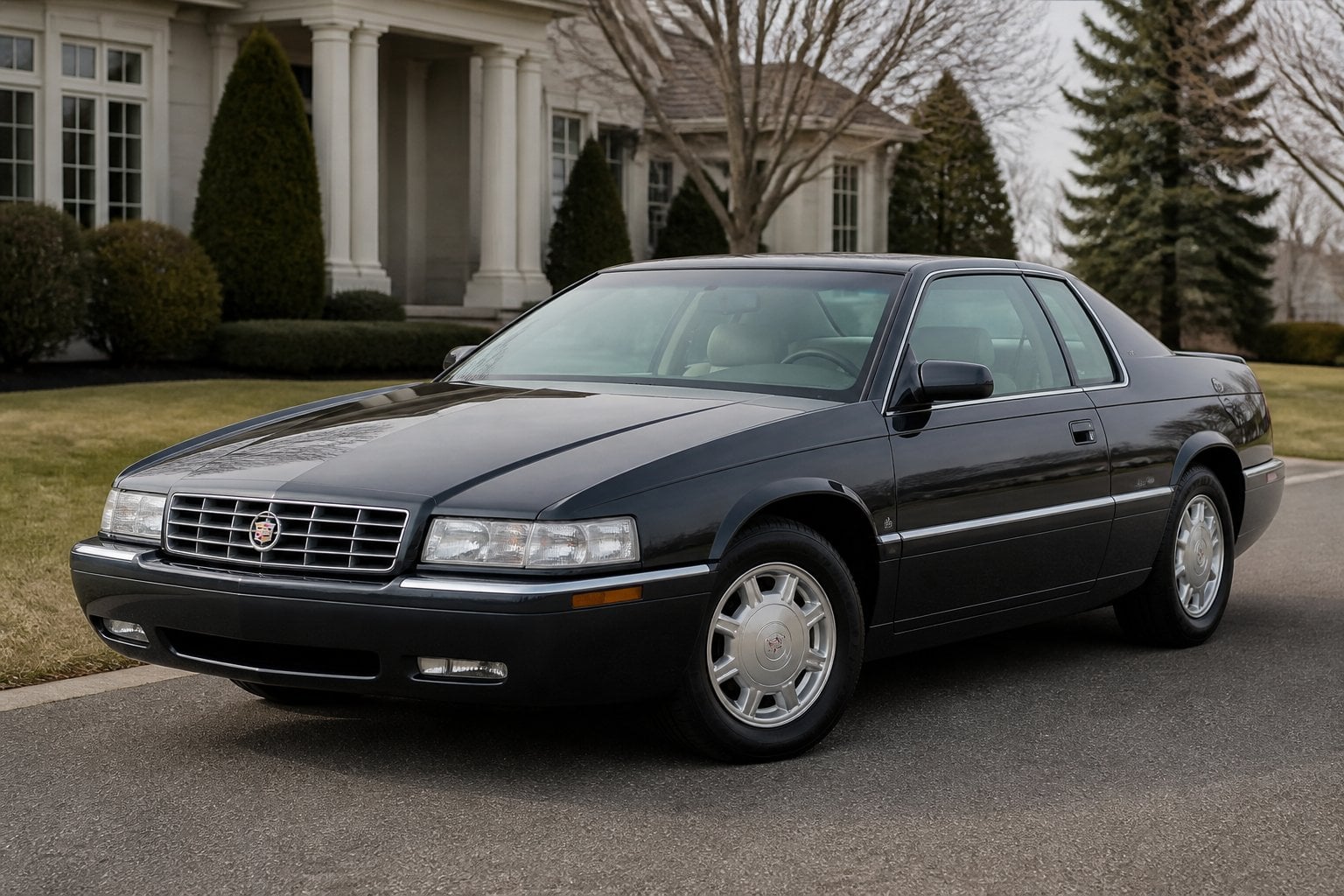 A dark metallic 1990s Cadillac Eldorado coupe parked on a suburban driveway.