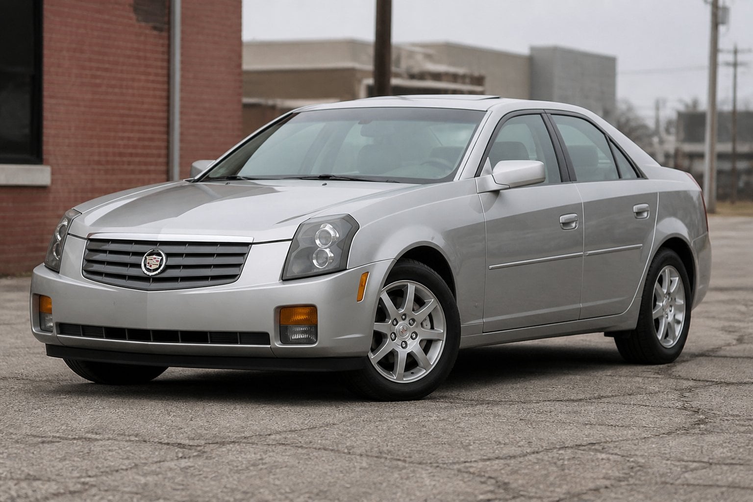 A first-generation Cadillac CTS sedan parked on a paved urban roadside.