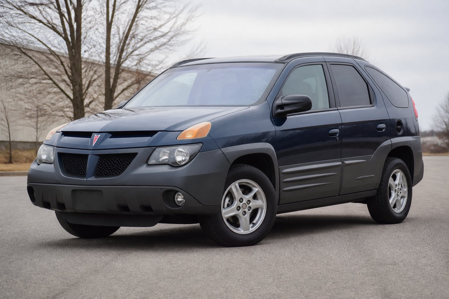 A Pontiac Aztek parked on a paved lot in an outdoor setting.