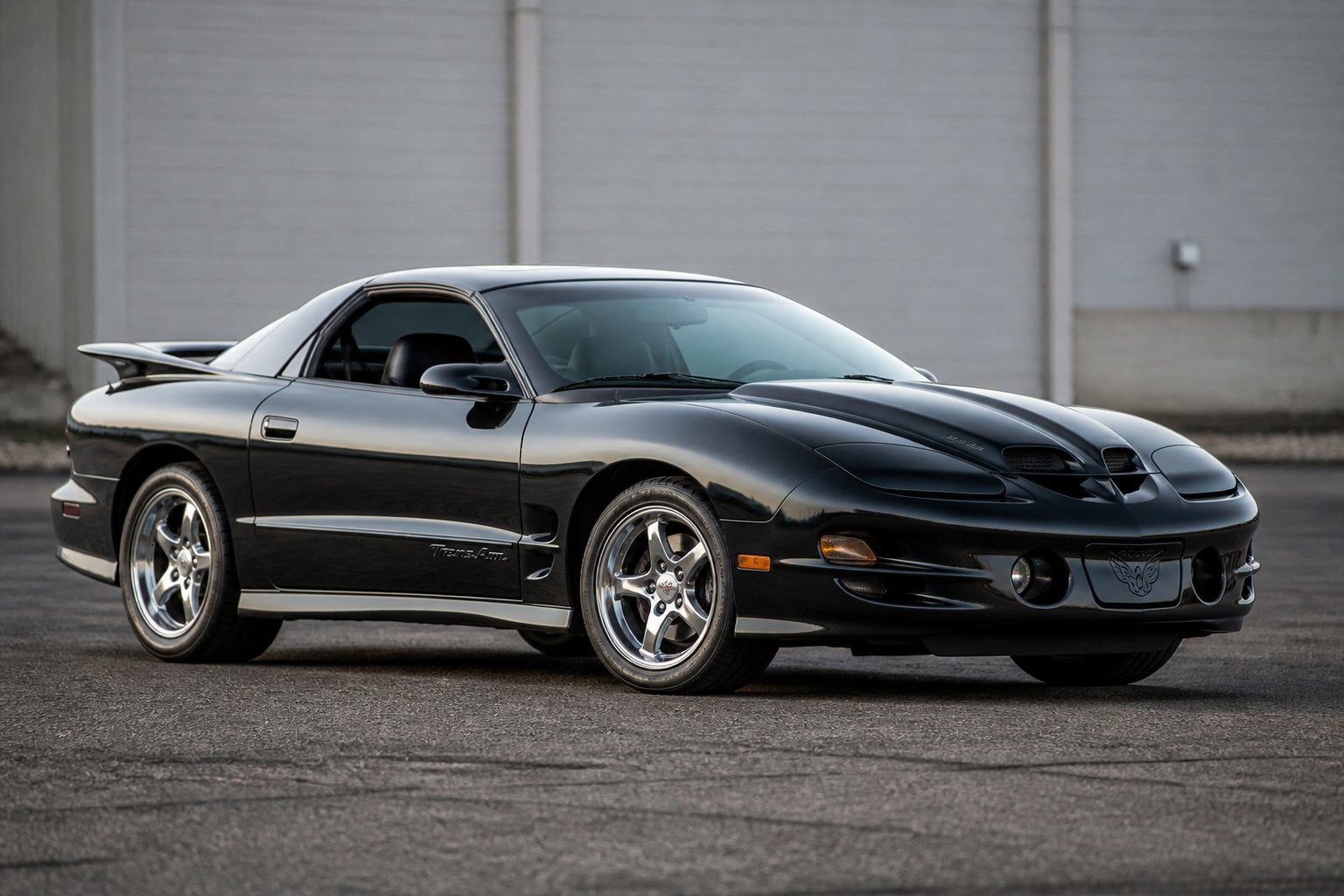 A Pontiac Firebird Trans Am WS6 sports coupe parked on asphalt, viewed from the front at an angle.