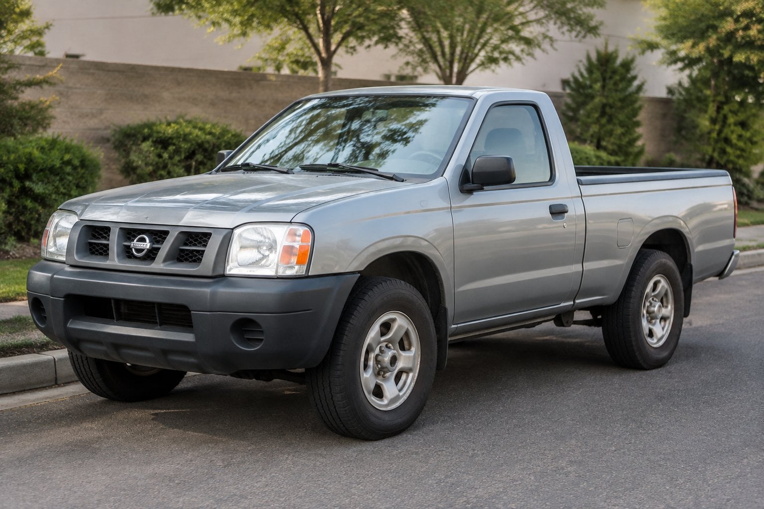 A 2005 Nissan Frontier pickup truck parked on a roadside in daylight.