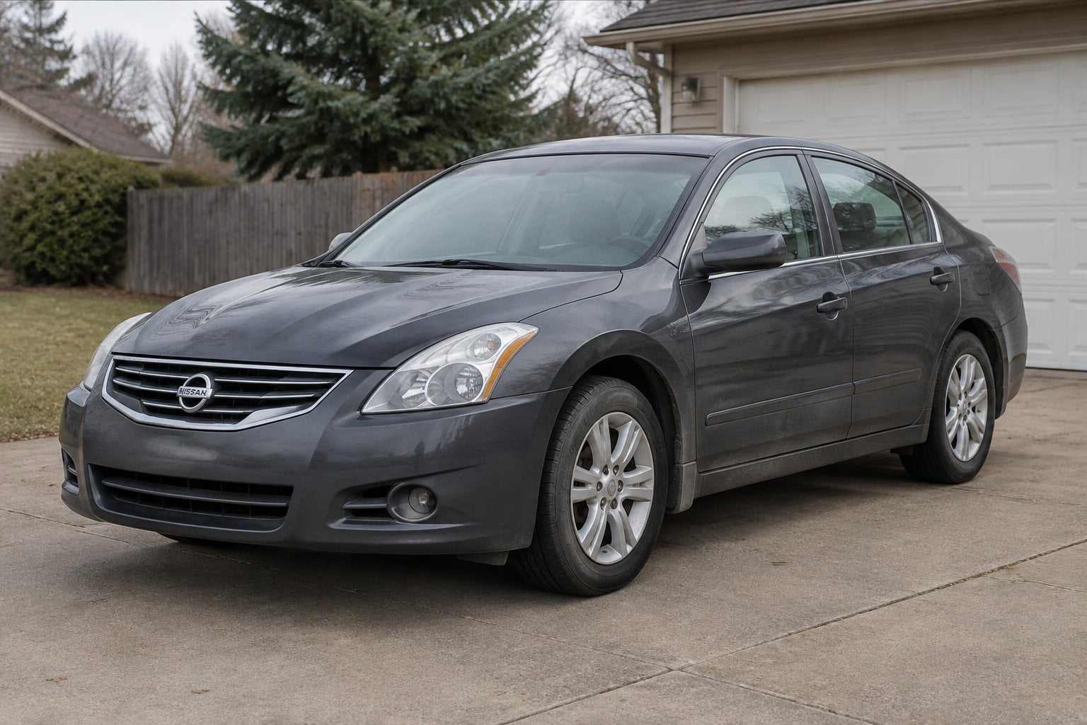A gray 2010 Nissan Altima sedan parked in a suburban driveway.