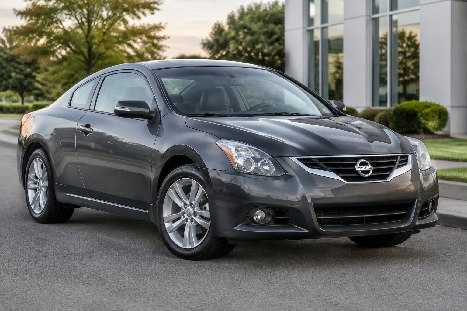 A gray 2013 Nissan Altima Coupe parked on a quiet roadside.