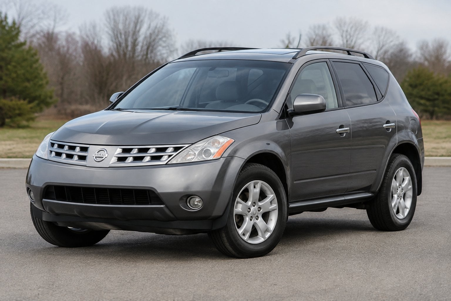 A silver 2004 Nissan Murano parked on a quiet roadside.
