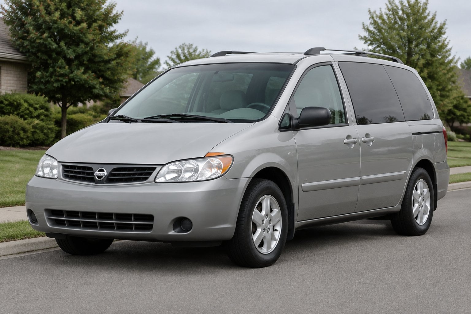 A 2003 Nissan Quest minivan parked on a suburban street.