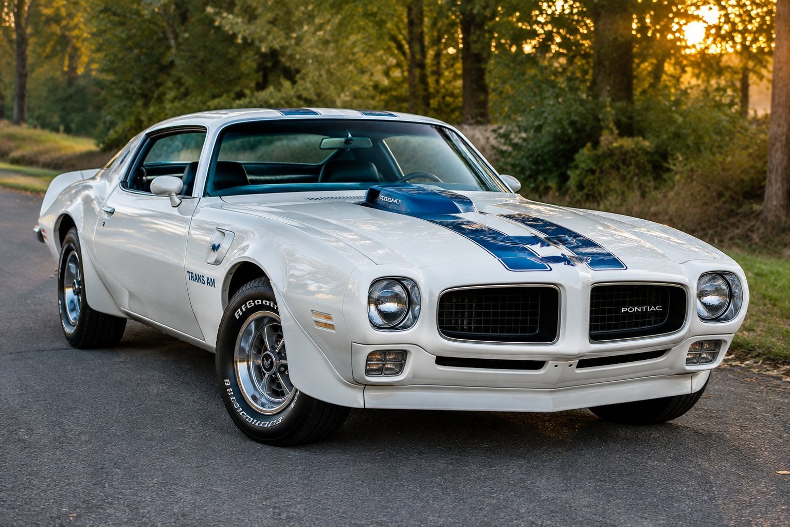 A white and blue 1970 Pontiac Trans Am parked on a quiet road.