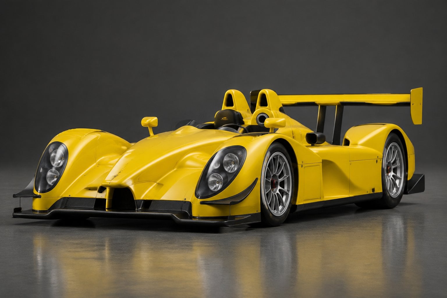 A Porsche RS Spyder race car displayed in a studio.