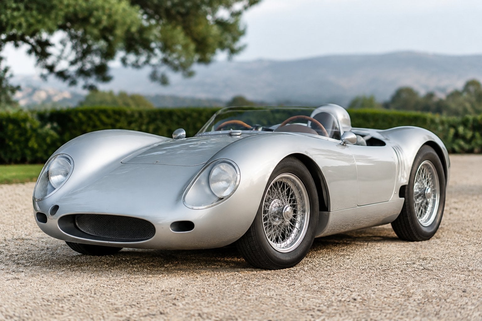 A vintage Porsche racing roadster displayed in a motorsport setting.