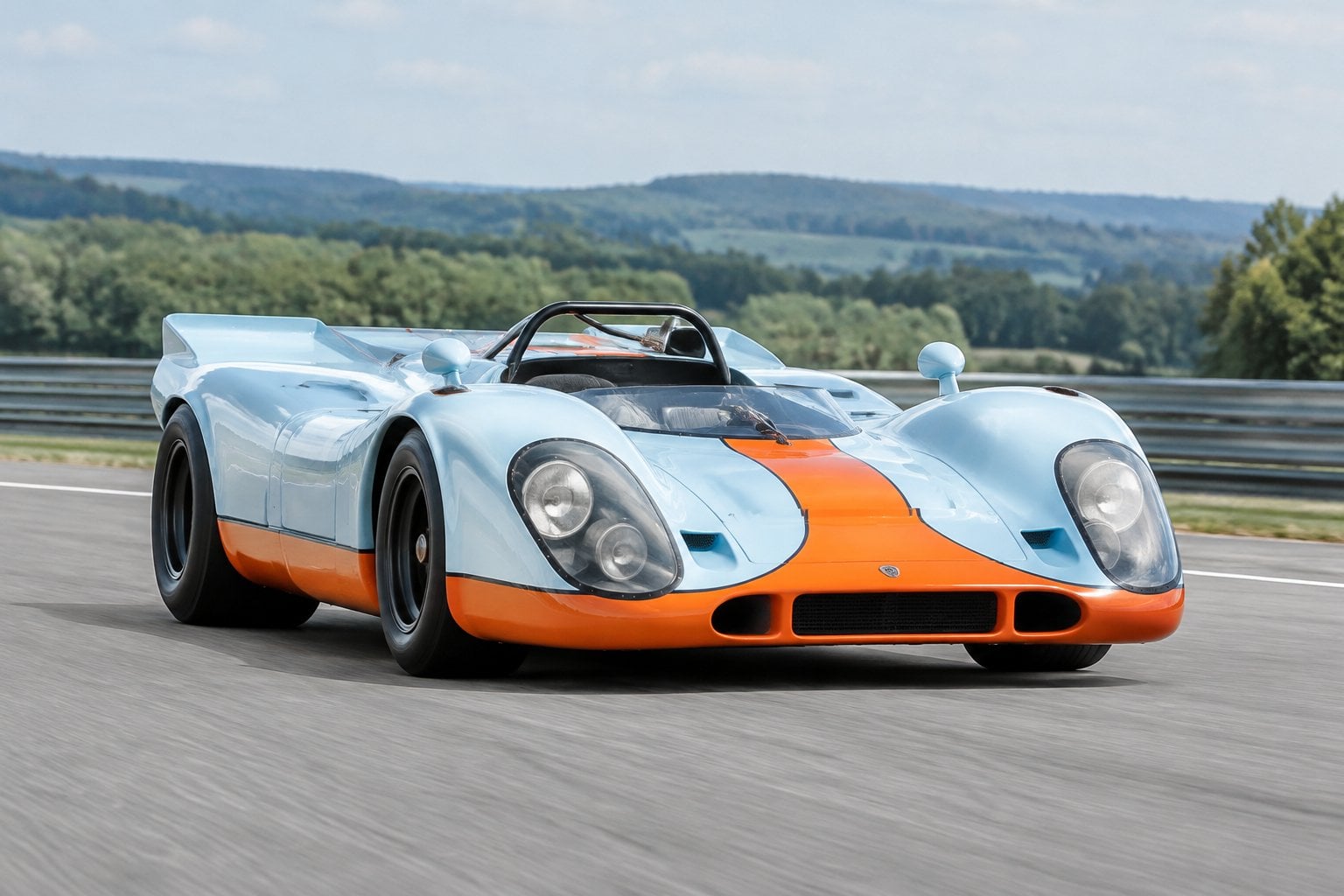 A vintage Porsche racing car driving on a race circuit.