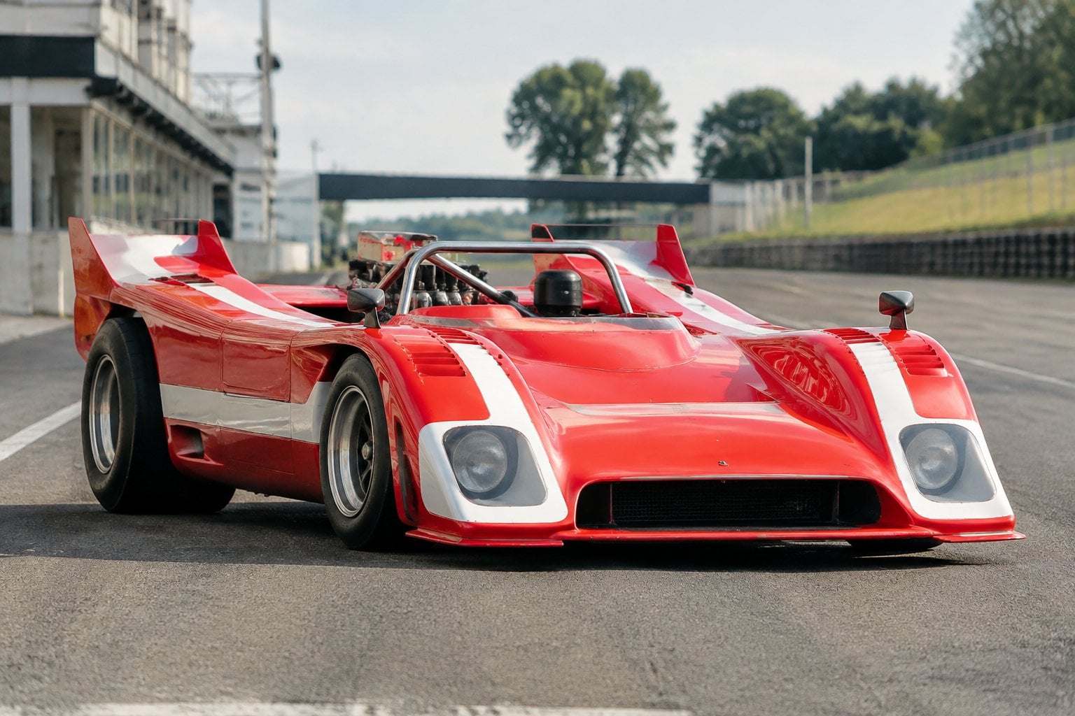 A vintage open-cockpit Porsche race car on a racetrack.