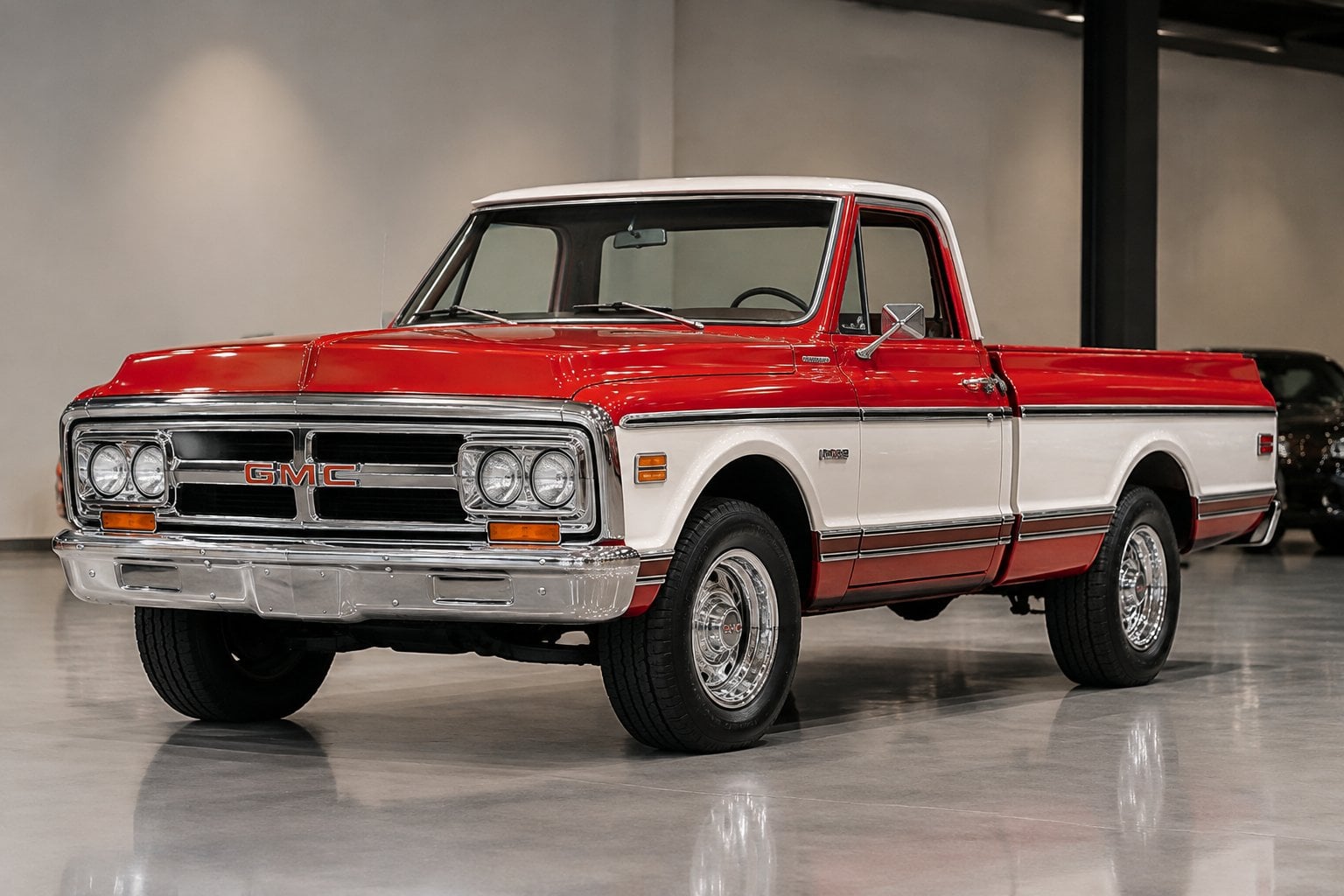 A restored vintage GMC pickup displayed at an indoor vehicle auction.