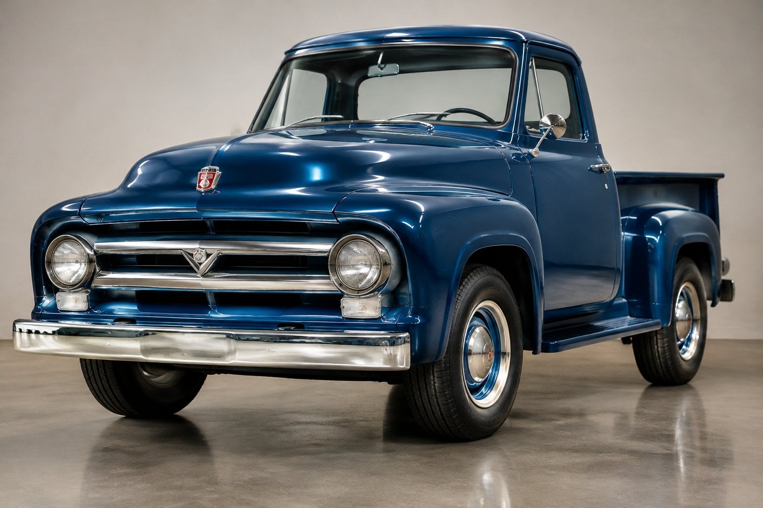 A blue 1956 Ford F-100 pickup truck displayed in a showroom.